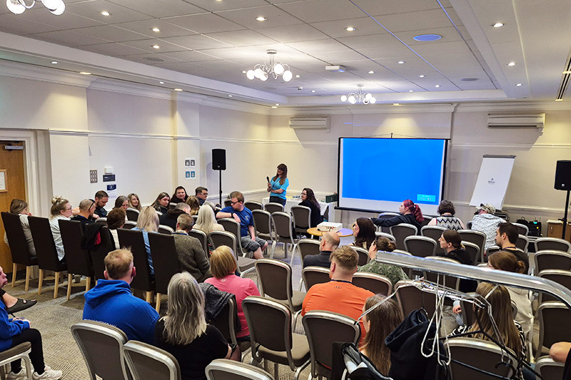 The meet and greet session - a room full of members sat in rows of chairs with a projector screen at the far end.